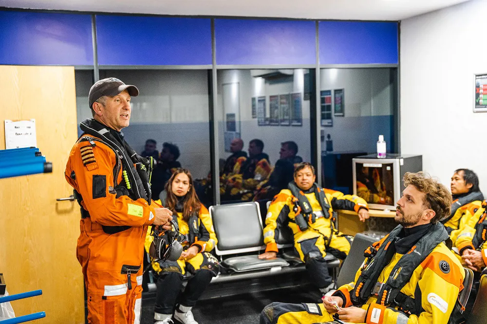 Staff in life jackets and uniform having a discussion