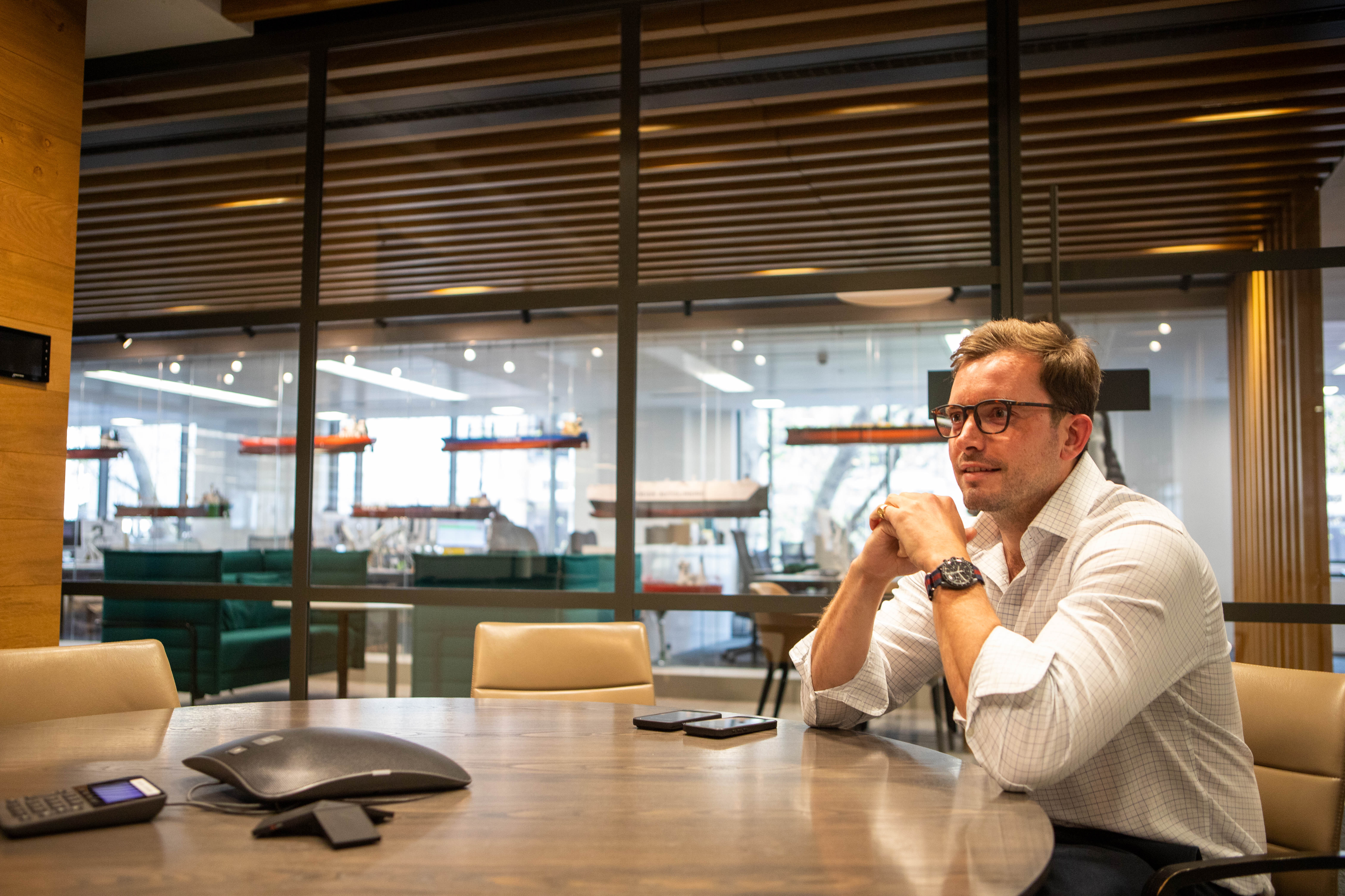 Man sitting at a table in a modern office.