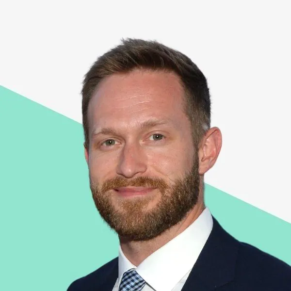 Smiling man with a beard in a suit.