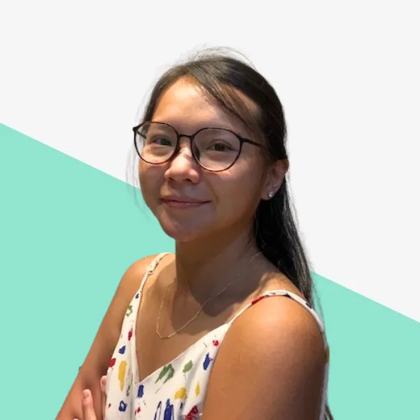 A young woman with glasses smiling confidently.