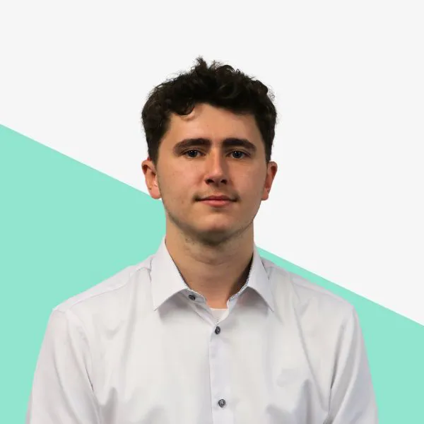 Young man in a white shirt against a teal background.