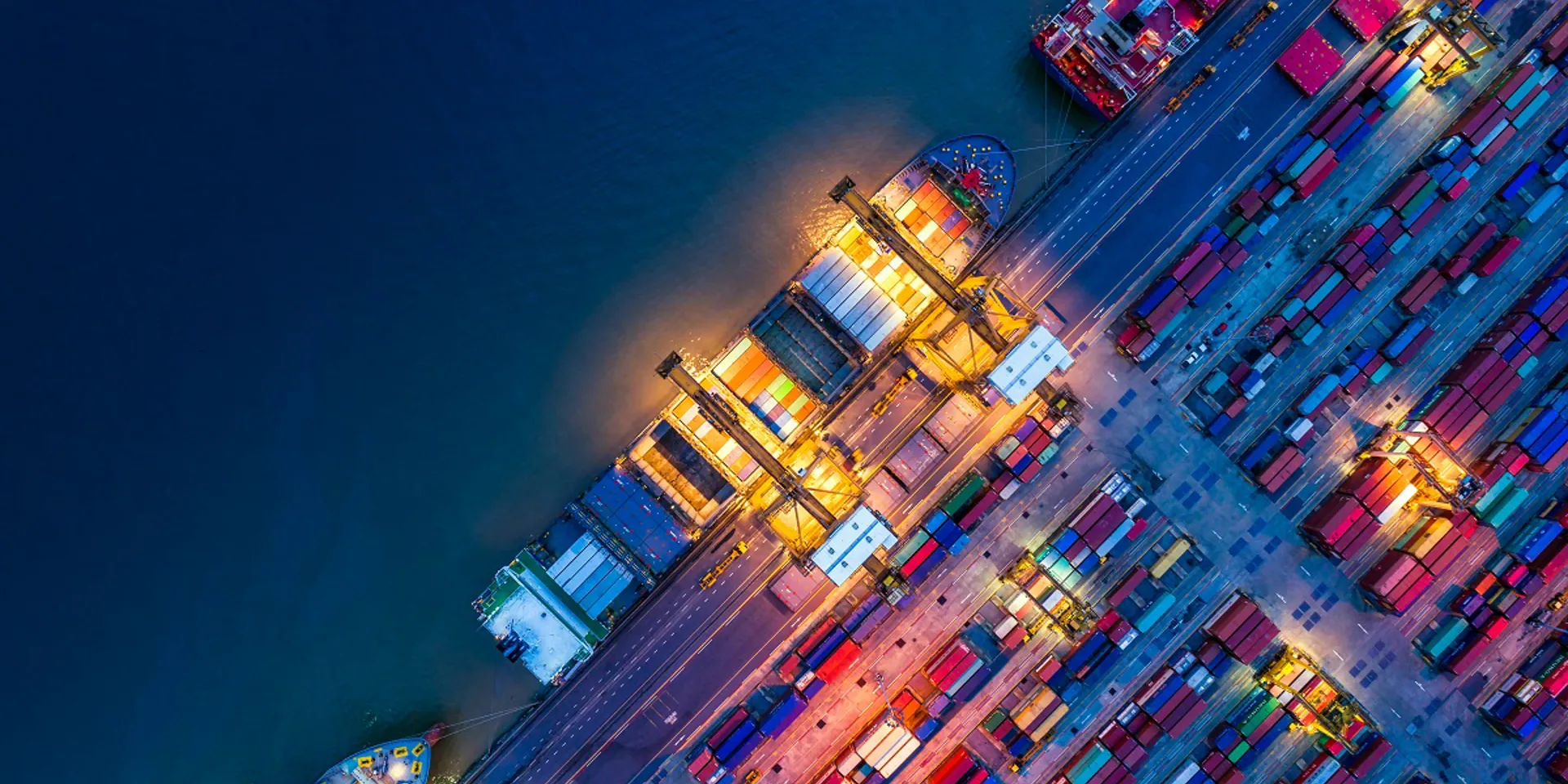 Aerial view of a busy cargo port at night.