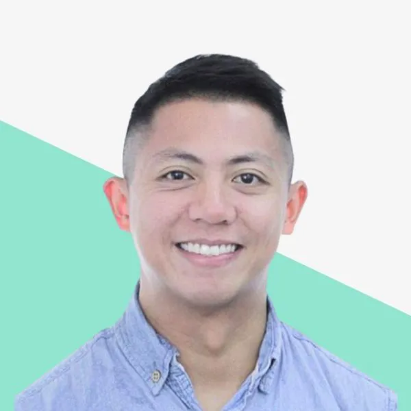 Smiling person in a button-up shirt on a background.