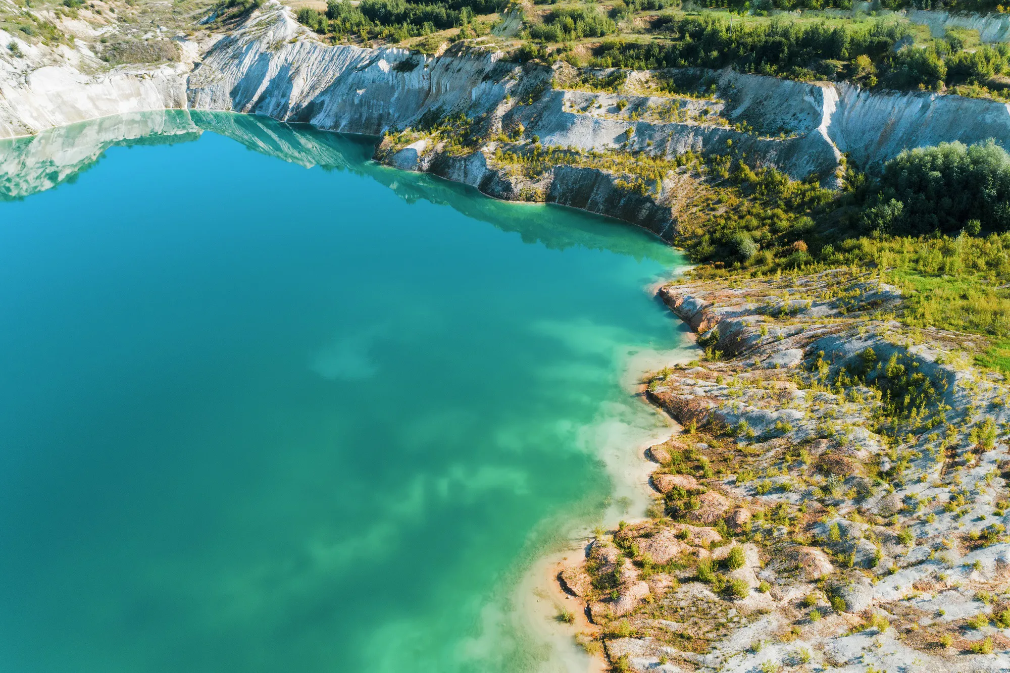 Inactive gypsum quarry. In the quarry is a lake with blue water.