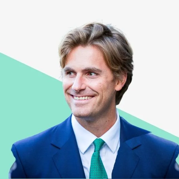 Smiling man in a suit with a green tie.