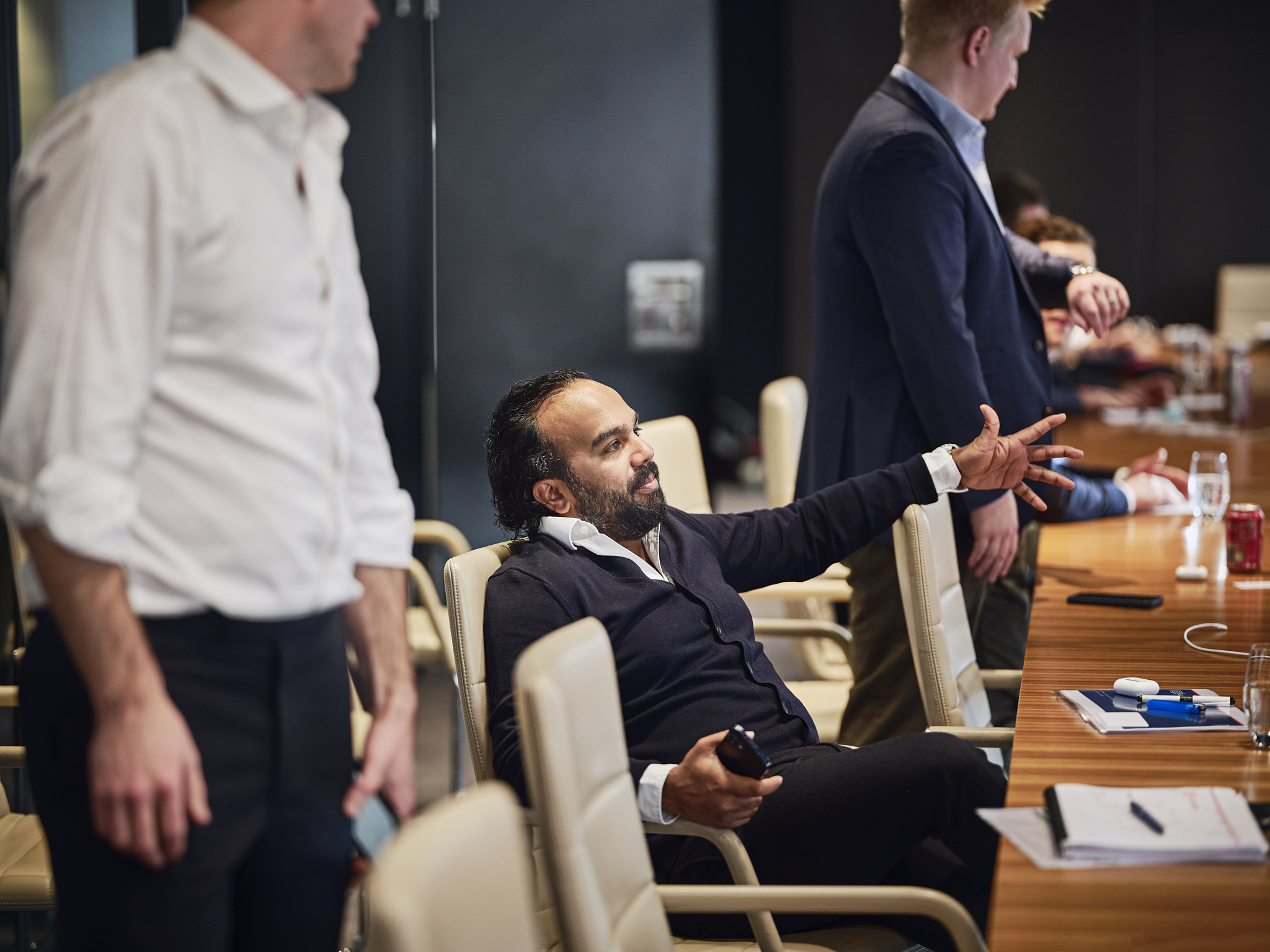 man sitting in a meeting room and pointing