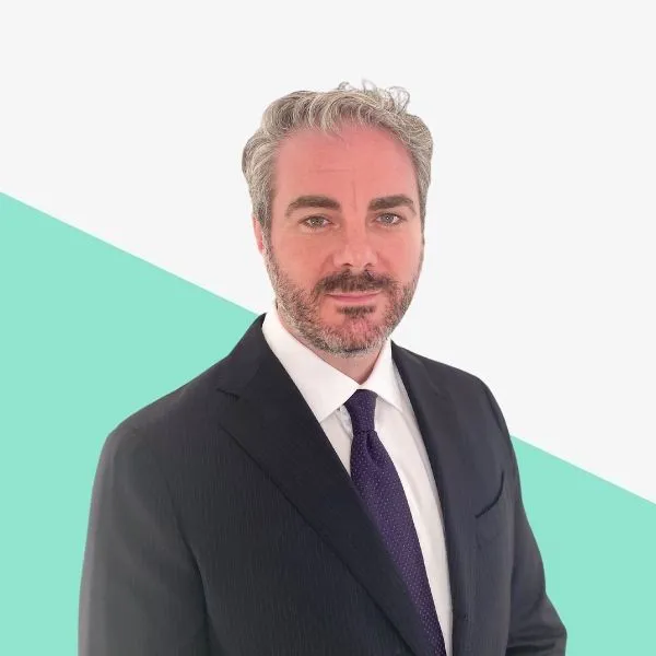 Man in a suit with light gray hair and beard.