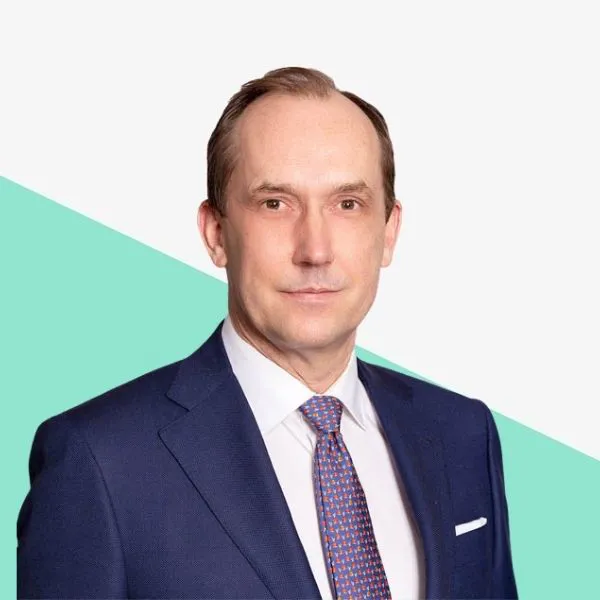 A man in a suit against a colorful background.