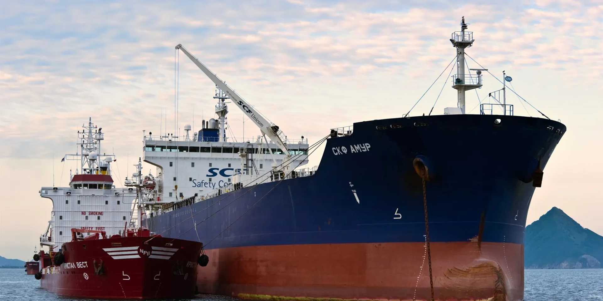 Two large ships docked in calm waters.