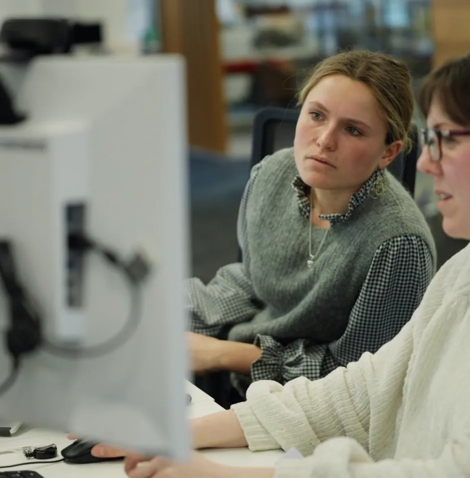 Two women collaborating at a computer.