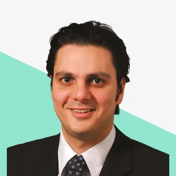 Smiling man in a suit with dark hair.