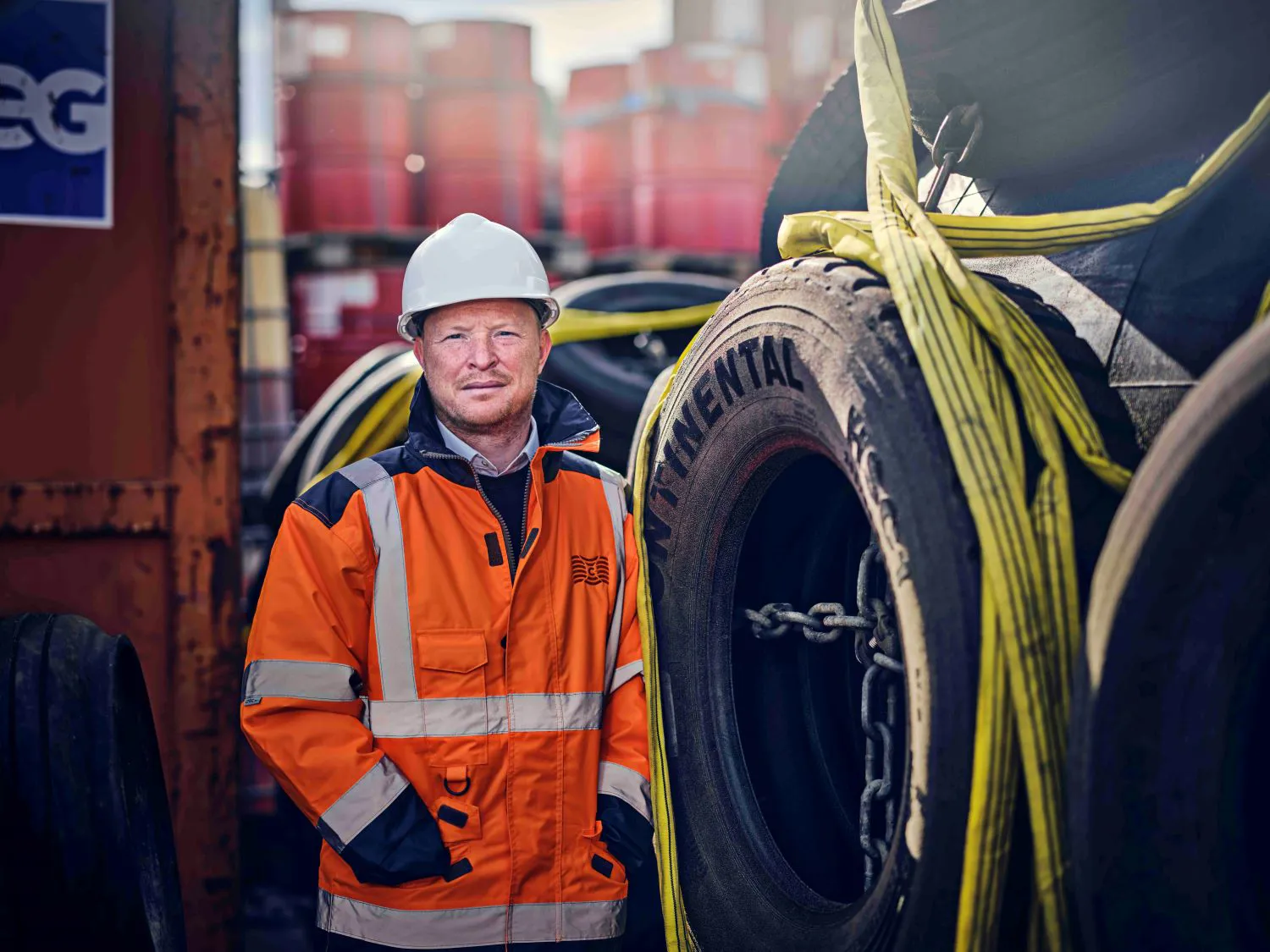 Man in hi-vis jacket with helmet stood by wheel