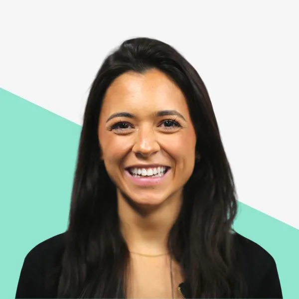 Smiling woman with long dark hair, light background.