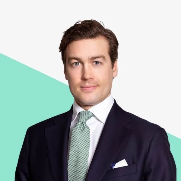 Man in a suit with a tie against a light background.