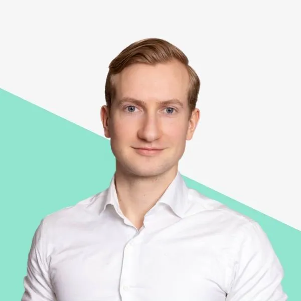 Man in a white shirt against a teal background.