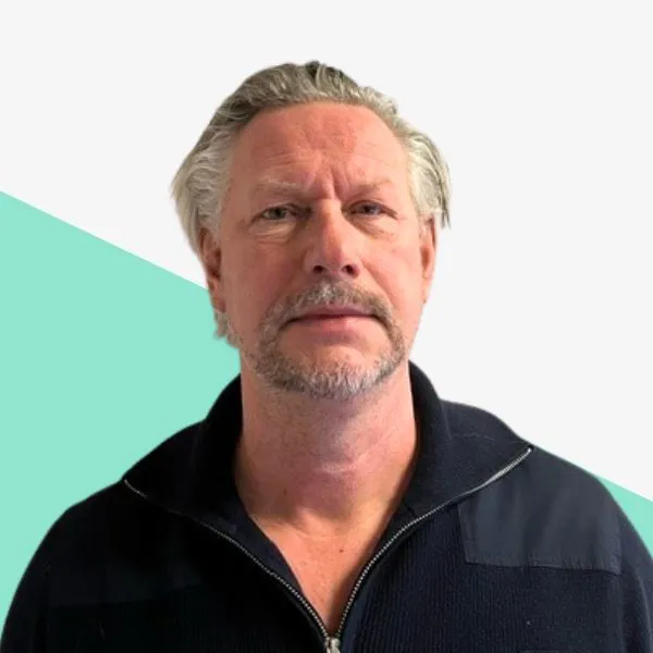 Man with light hair and beard, wearing a dark jacket.