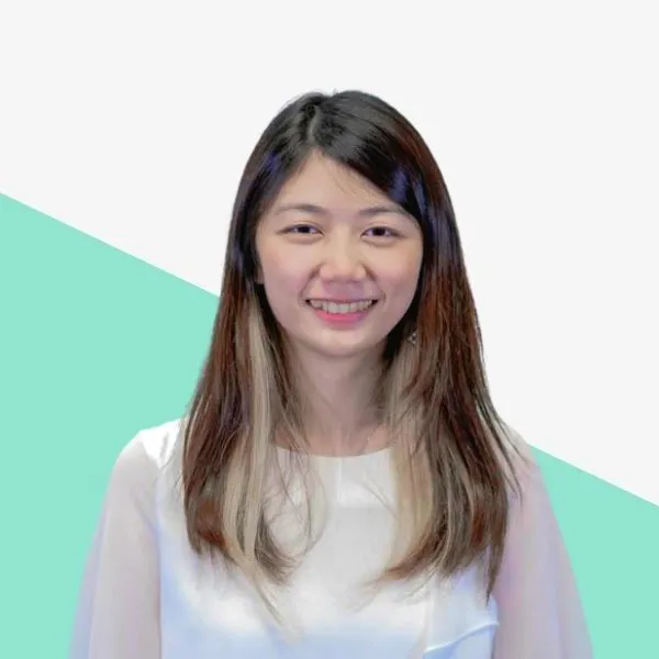 Woman with long hair smiling against a light background.