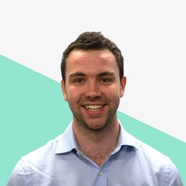 Smiling man in a light blue shirt against a background.