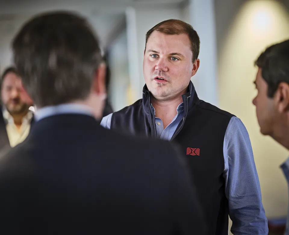 Group of men engaged in conversation indoors.