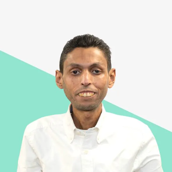 Man in a white shirt with a teal background.