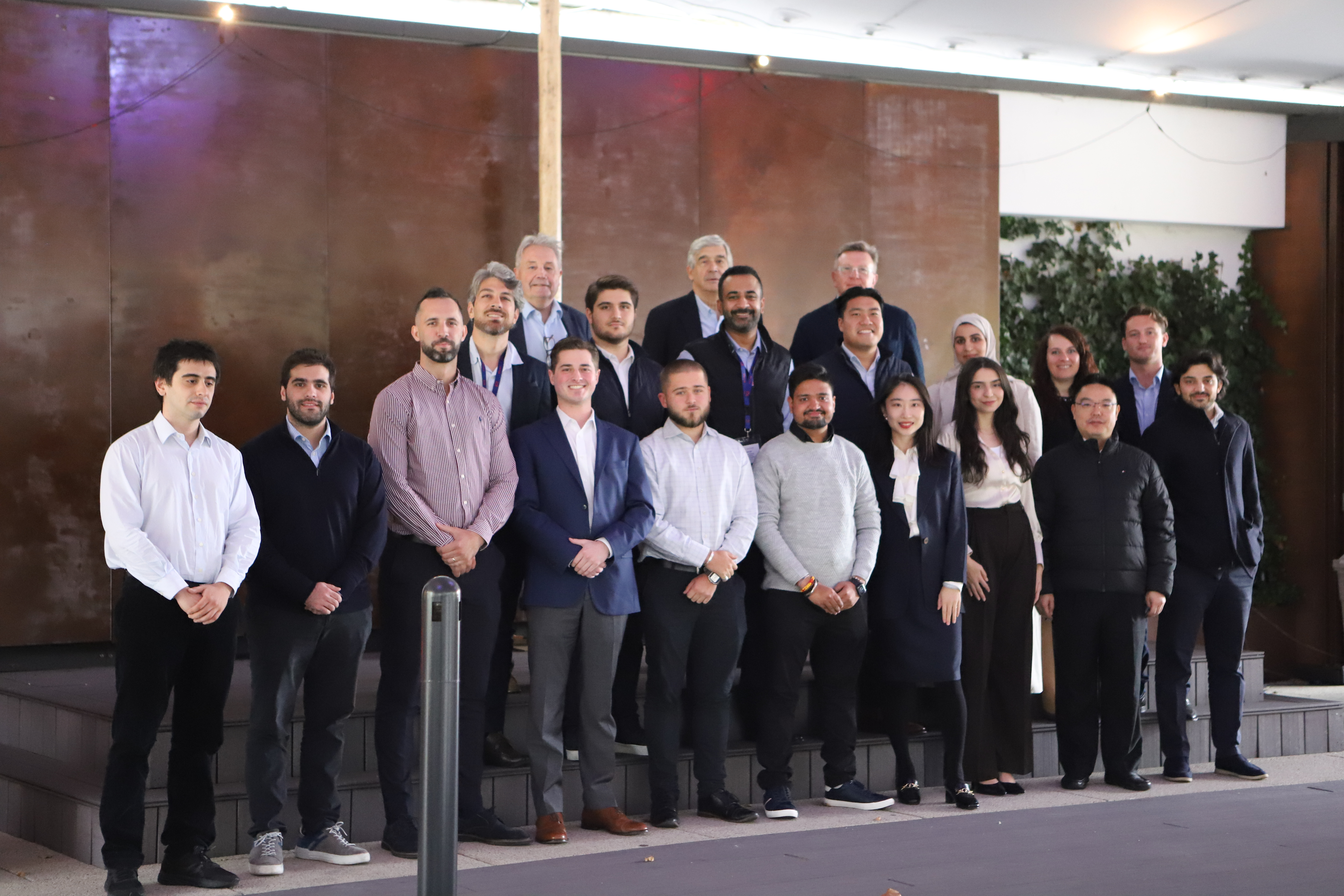 Diverse group in business attire standing outdoors in two rows.
