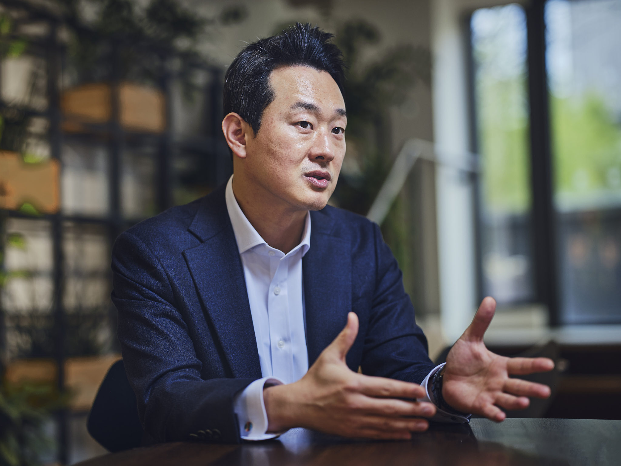 man sitting at table talking and gesturing with hands