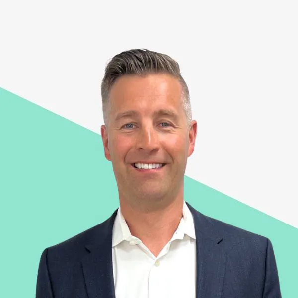 Smiling man in a suit against a light background.
