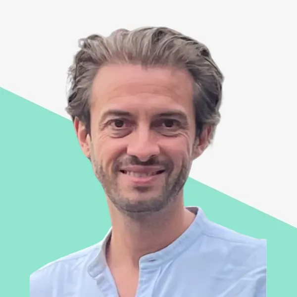 Smiling man with light hair in a blue shirt.