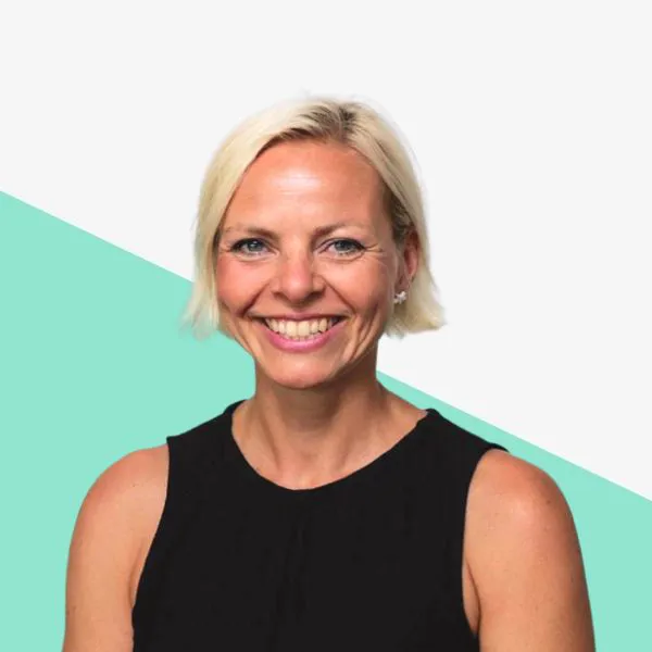 Smiling woman with short blonde hair, black top.