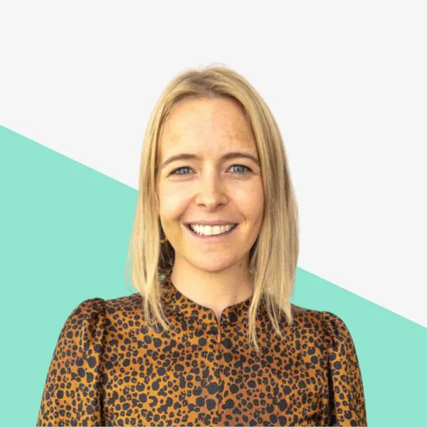 Smiling woman with blonde hair in leopard print top.