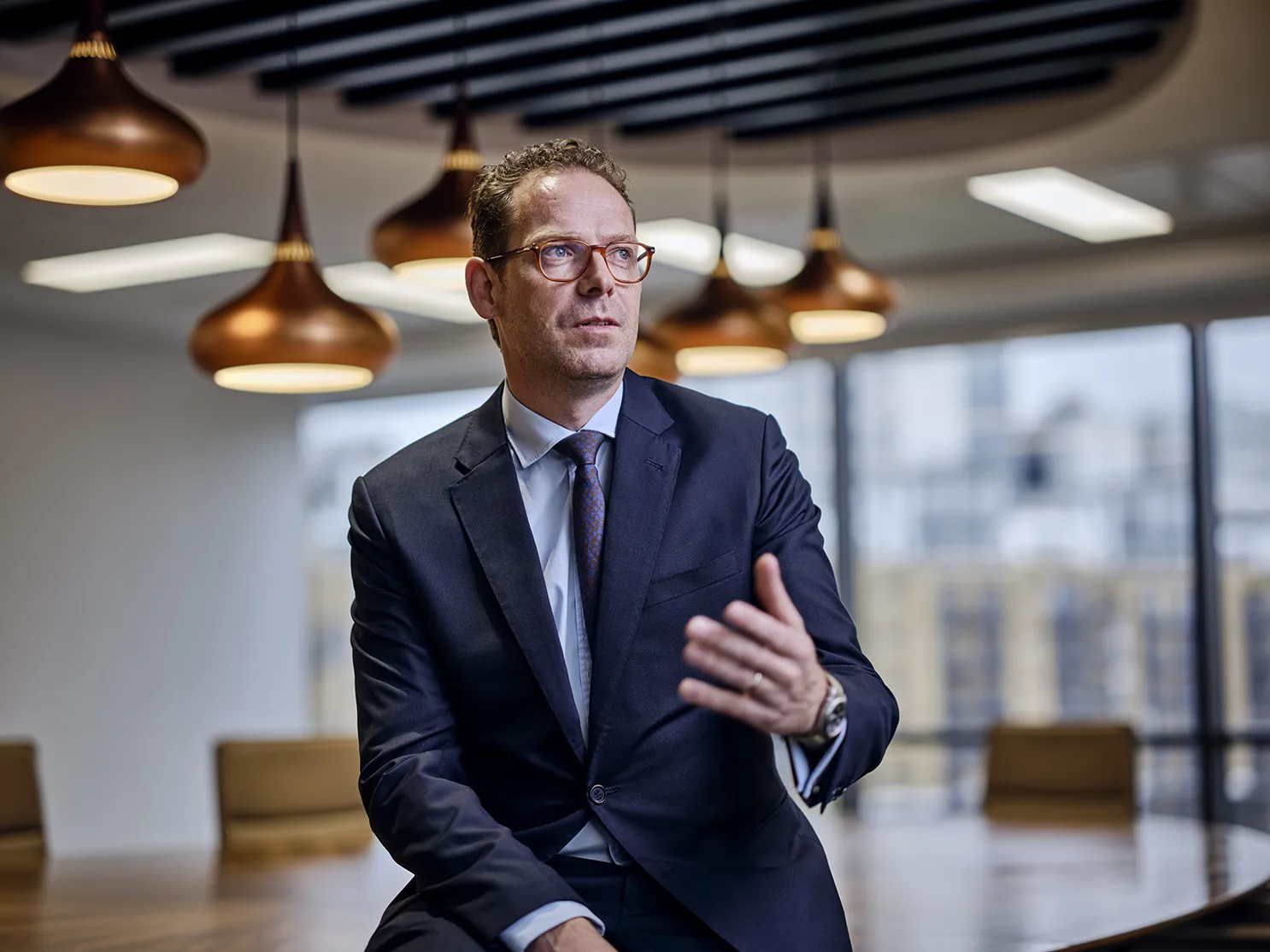 Duncan Lyall, head of carbon credit broking gesturing to others in a board room