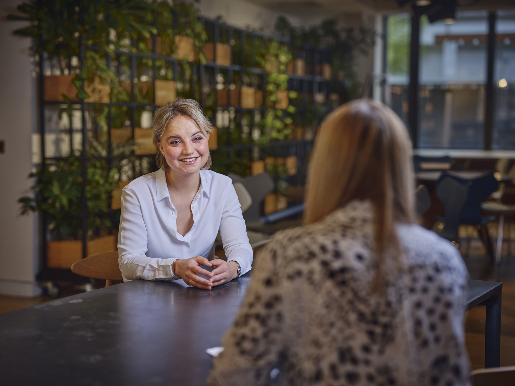 woman sitting at table, talking, smiling
