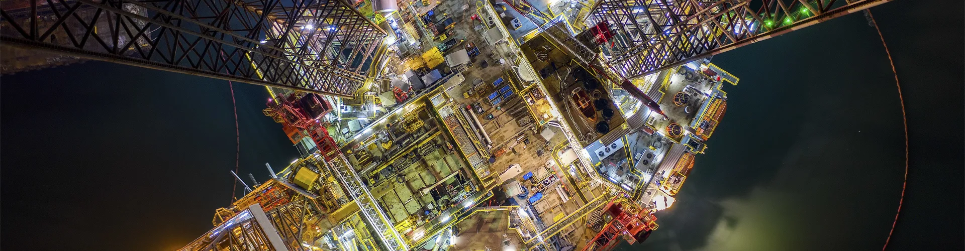 Oil and gas jack-up rig at the yard for maintenance with many vessels in the night time, the petroleum rig is applied for producing oil and gas in offshore in the petroleum industry