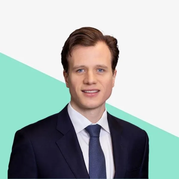 Man in a suit with a light background.