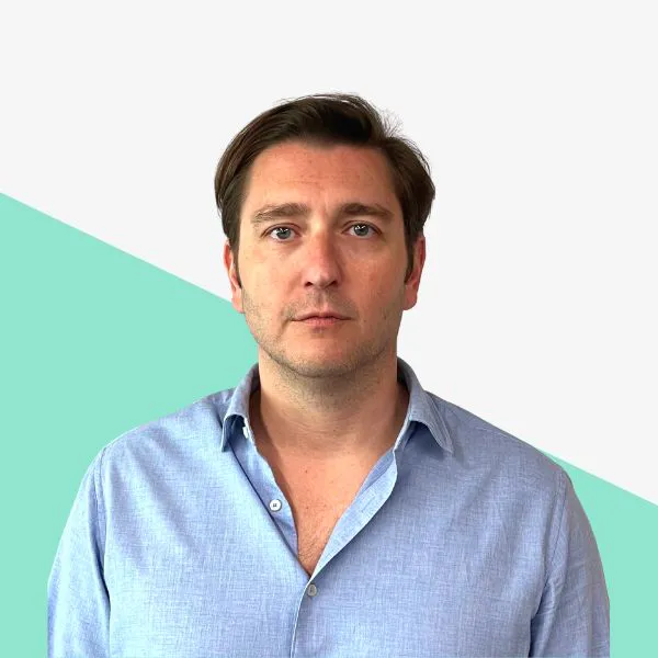 Man with short hair in a blue shirt, neutral expression.