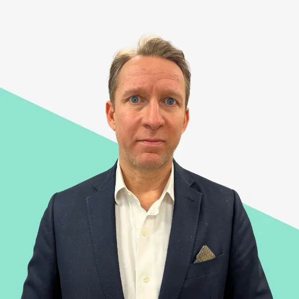 Man in a suit against a geometric background.