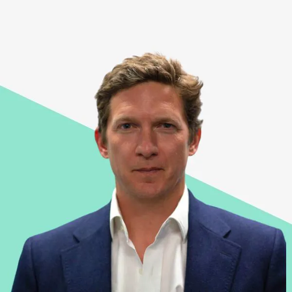 Man in a suit against a geometric background.