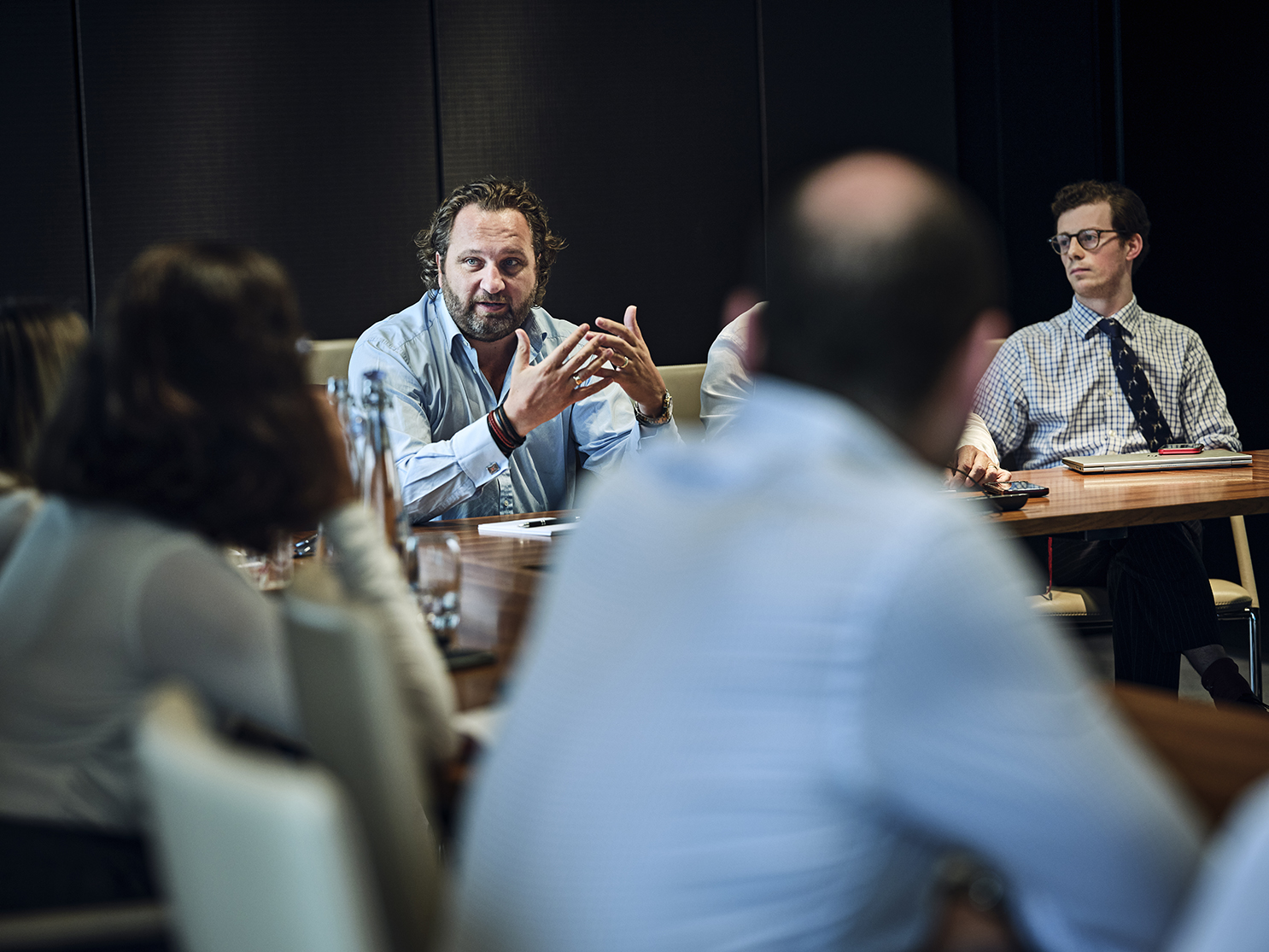 CEO talking sat at meeting table with analysts
