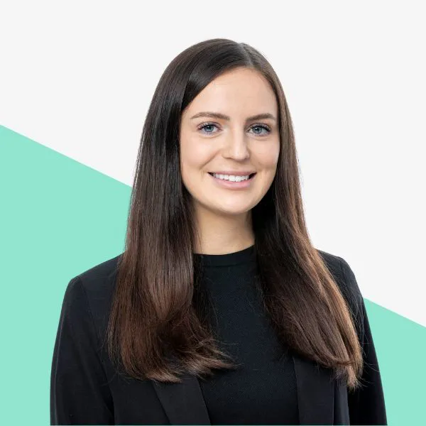 Smiling woman with long hair in a black blazer.