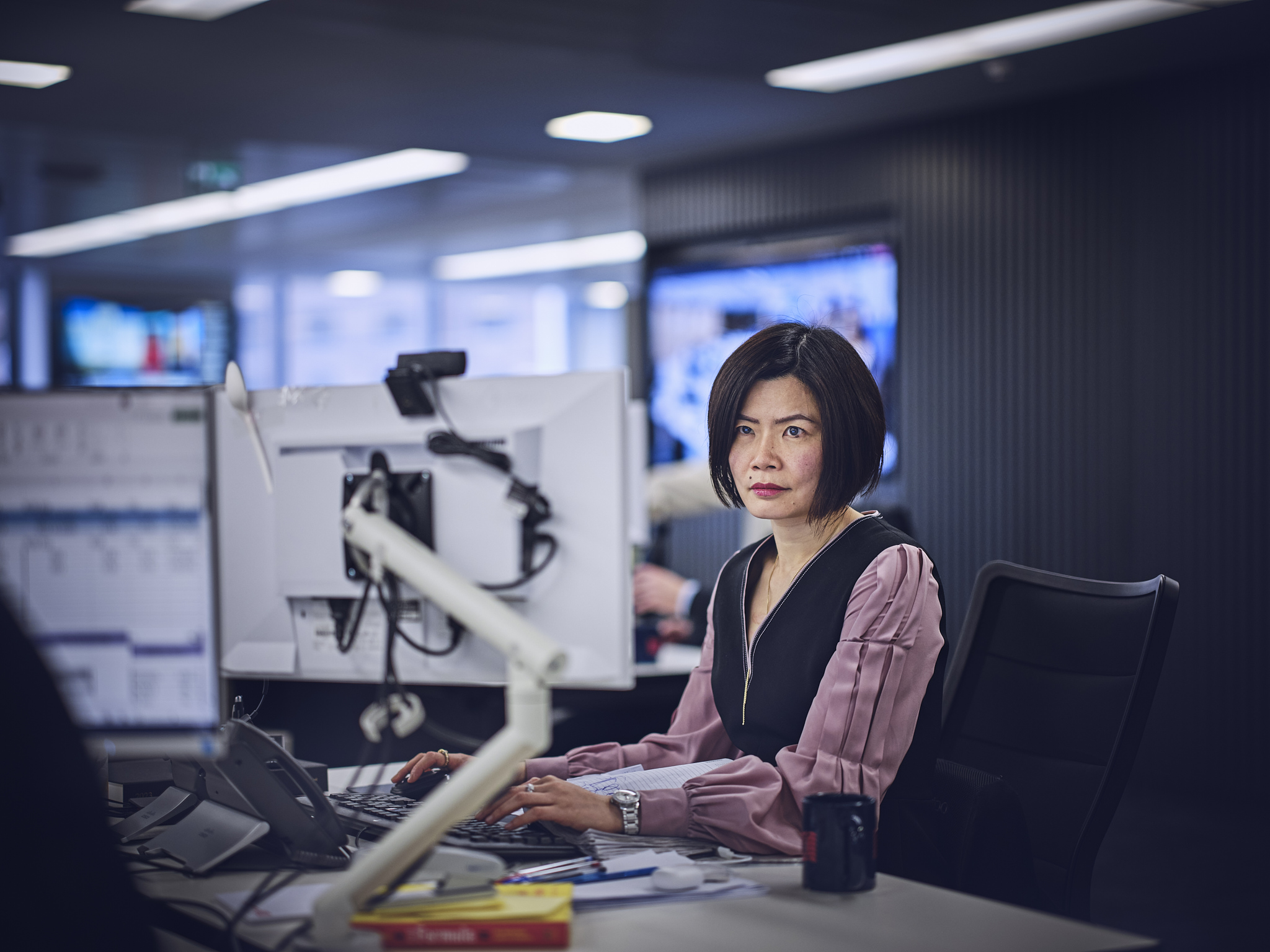 woman working at a desk, looking at computer screen