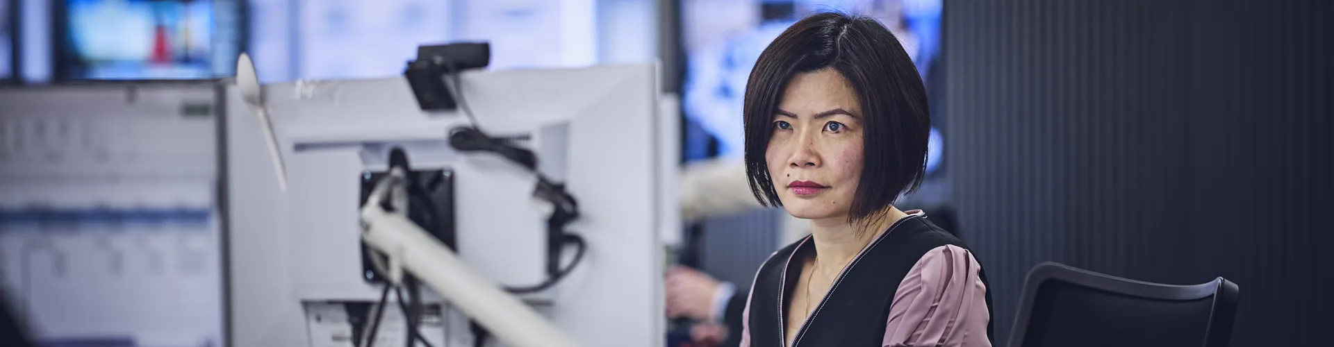 woman working at a desk, looking at computer screen