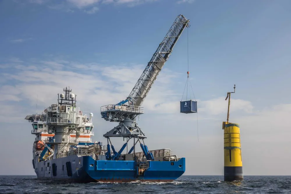 Cargo ship with crane lifting container at sea.