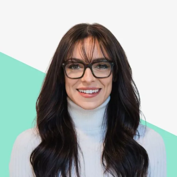 Person with long hair and glasses smiling.
