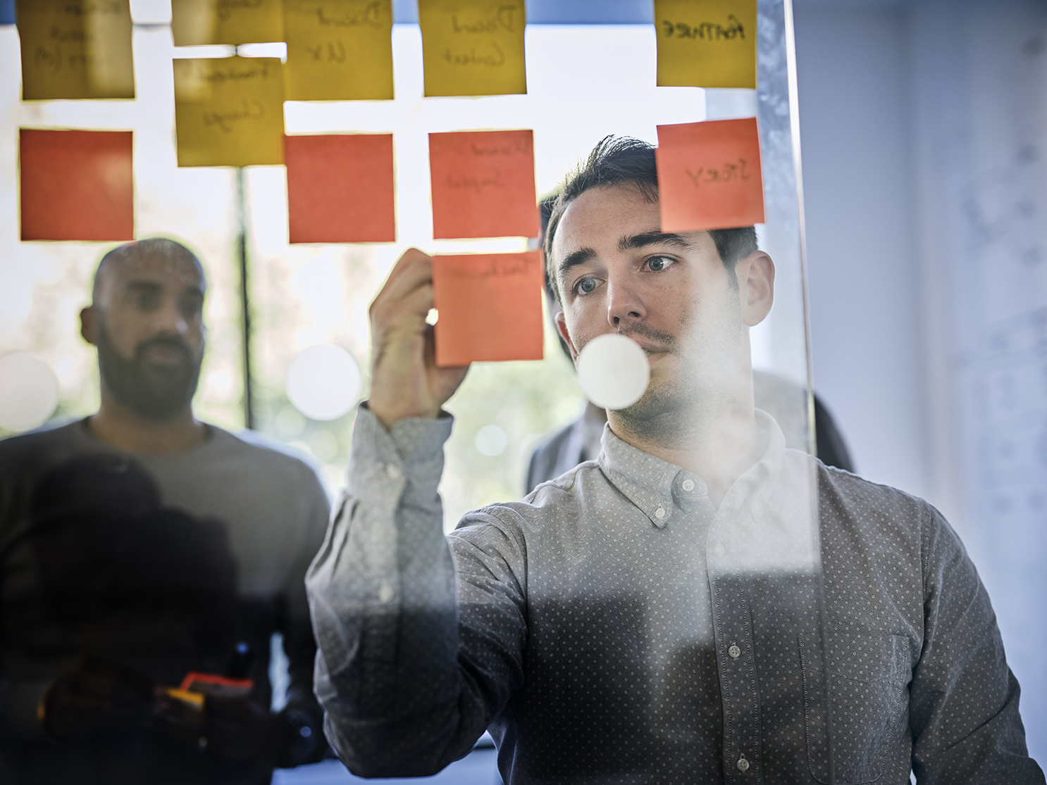 close up of man writing notes on the wall in a meeting