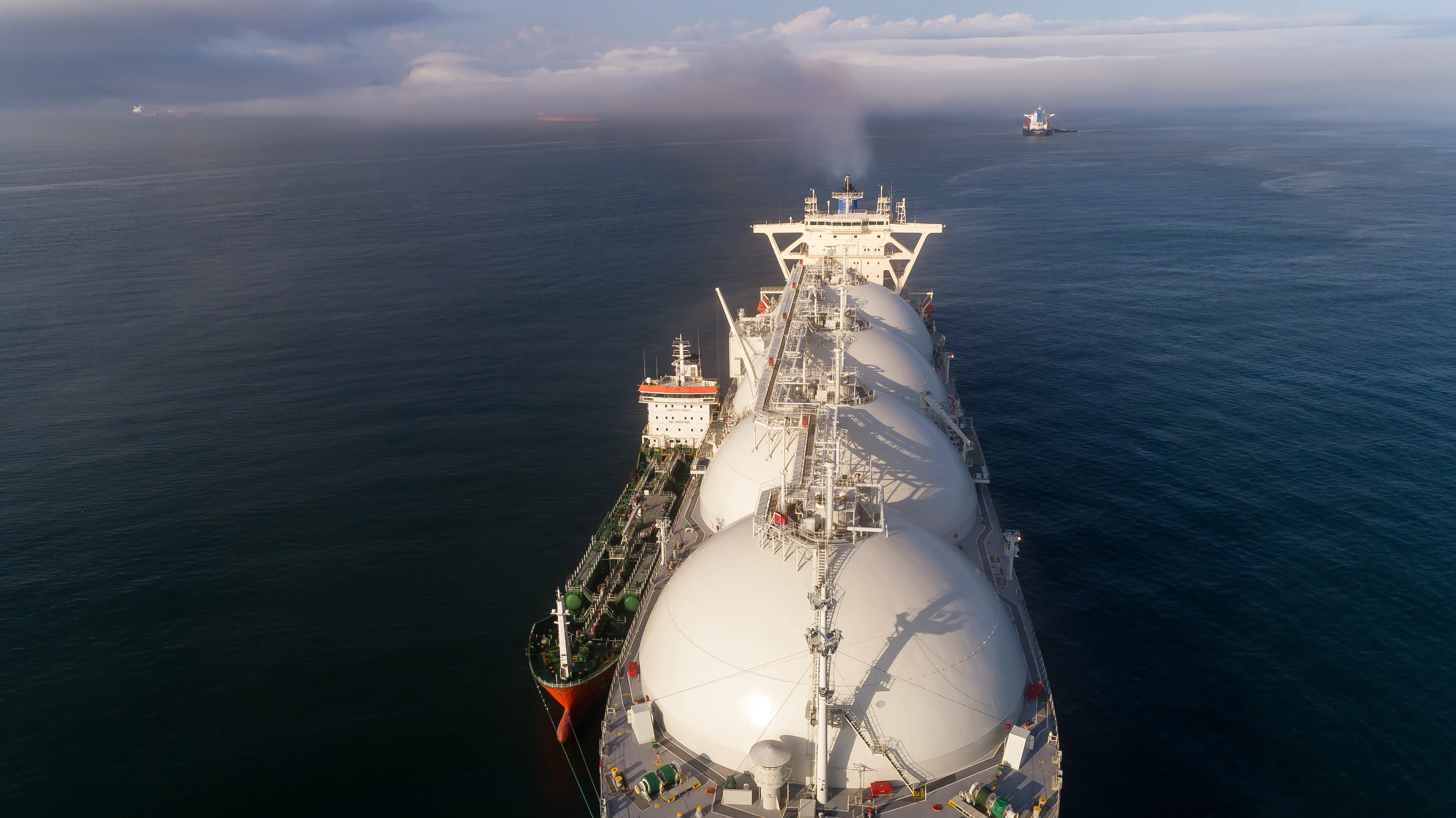 Top view of a large LNG tanker and a tanker standing side by side.