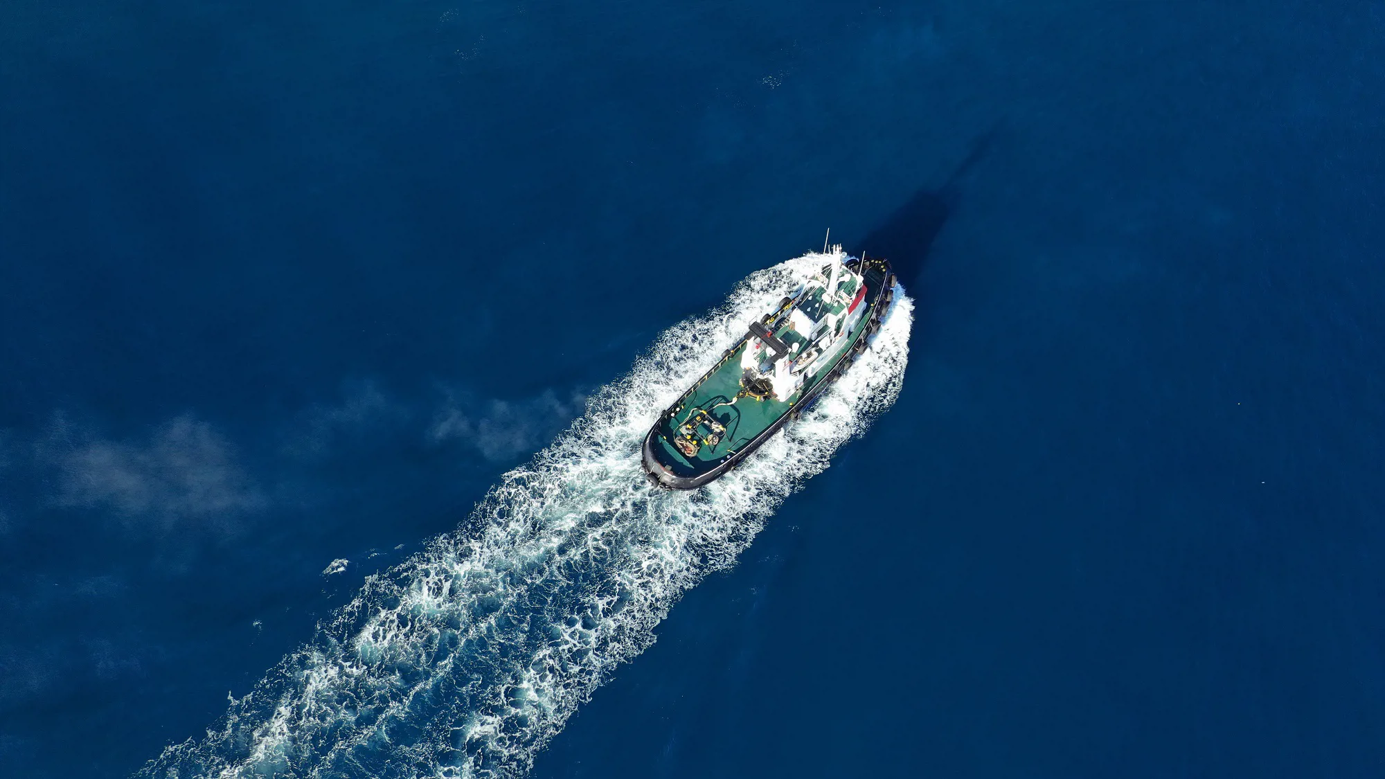 Aerial drone photo of tug boat cruising Mediterranean port