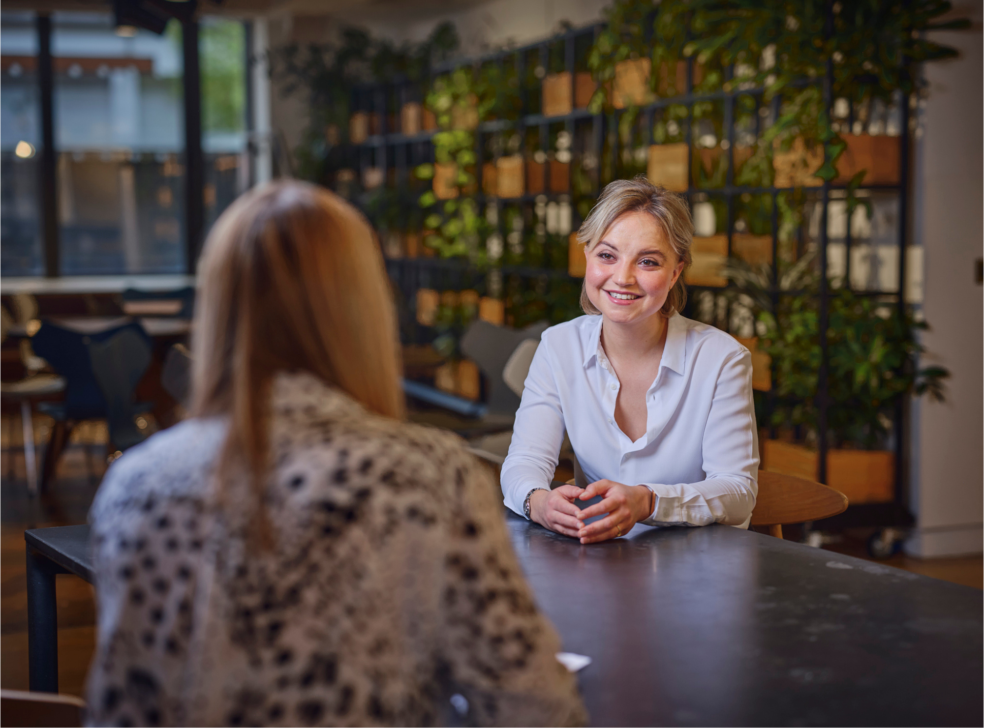 two women sitting at a table talking