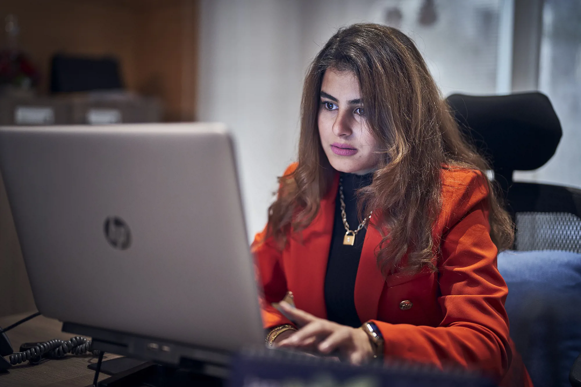 close up of a woman on a laptop in an office