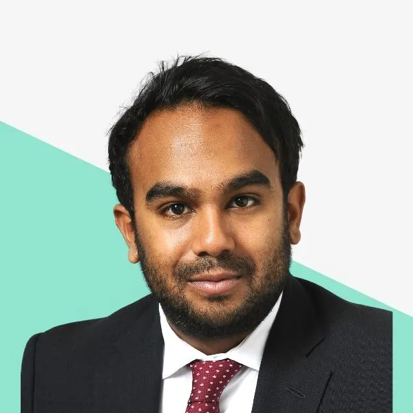 Man in a suit with a tie against a light background.