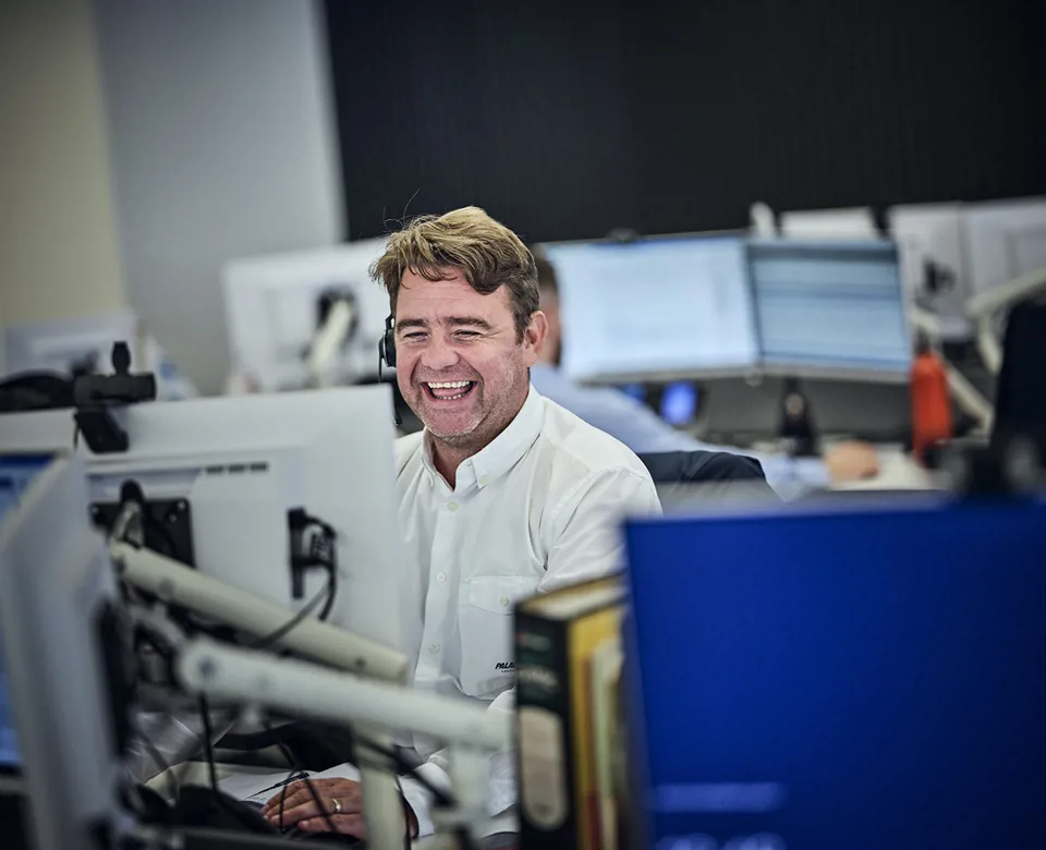 man laughing on the phone with his headset in the office